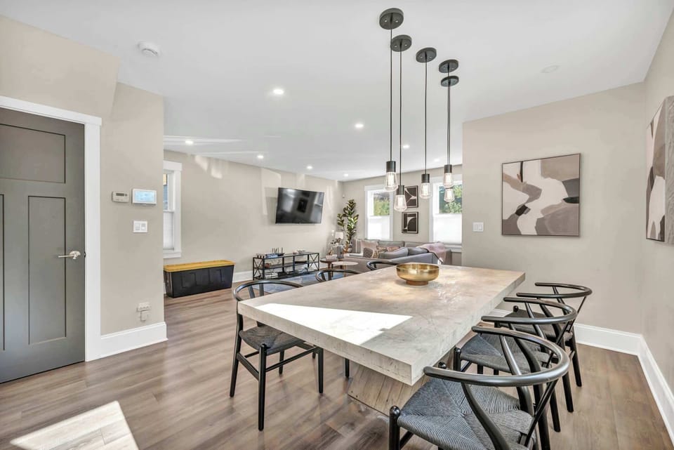 This sleek dining area features a modern table and artistic touches, offering a cozy space to share stories and savor delicious meals.