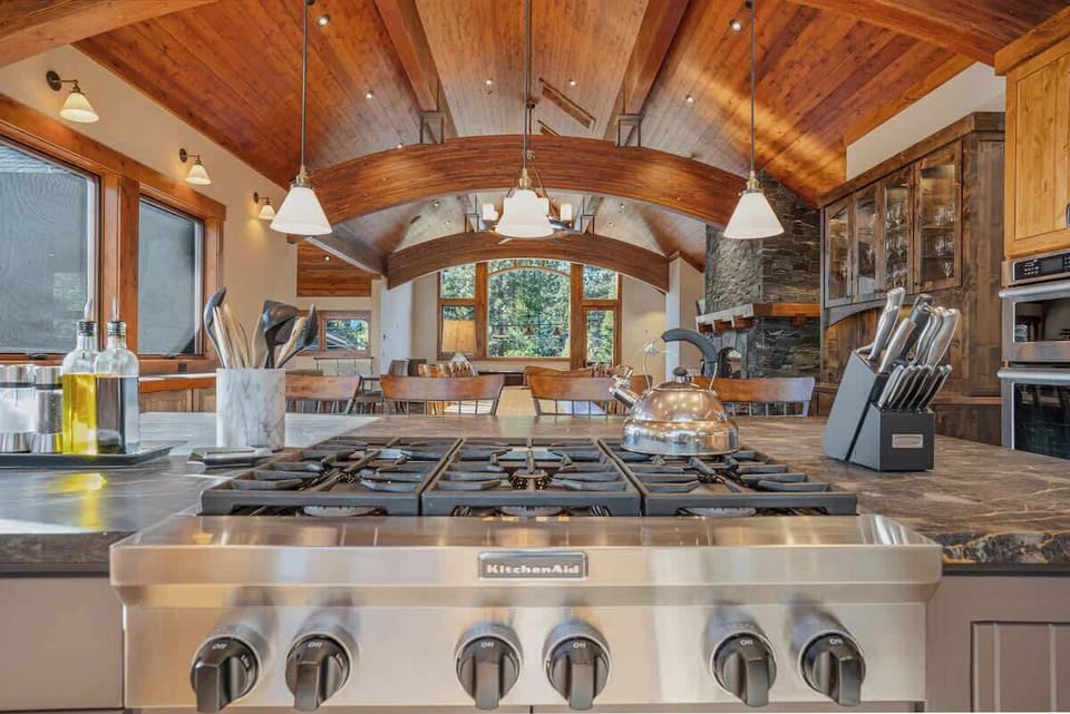 Kitchen with gas stovetop built-in to the large stone island with additional seating