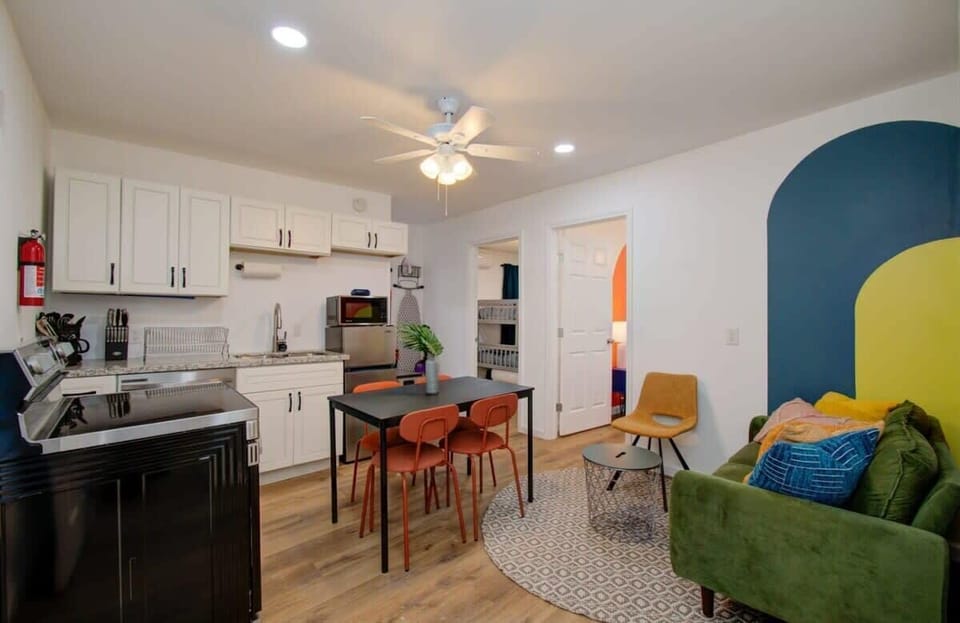 This open-concept living space is both functional and playful with a fully equipped kitchen, a sit-down dining area, and a dedicated sitting space.