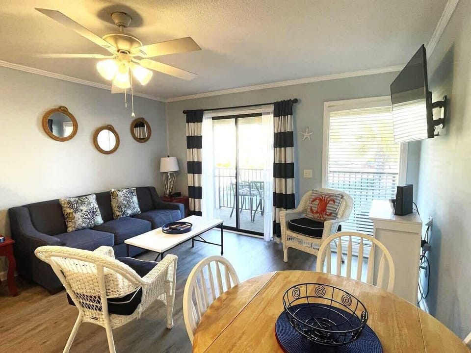 A navy blue sofa with patterned accent pillows sits across from a white coffee table.