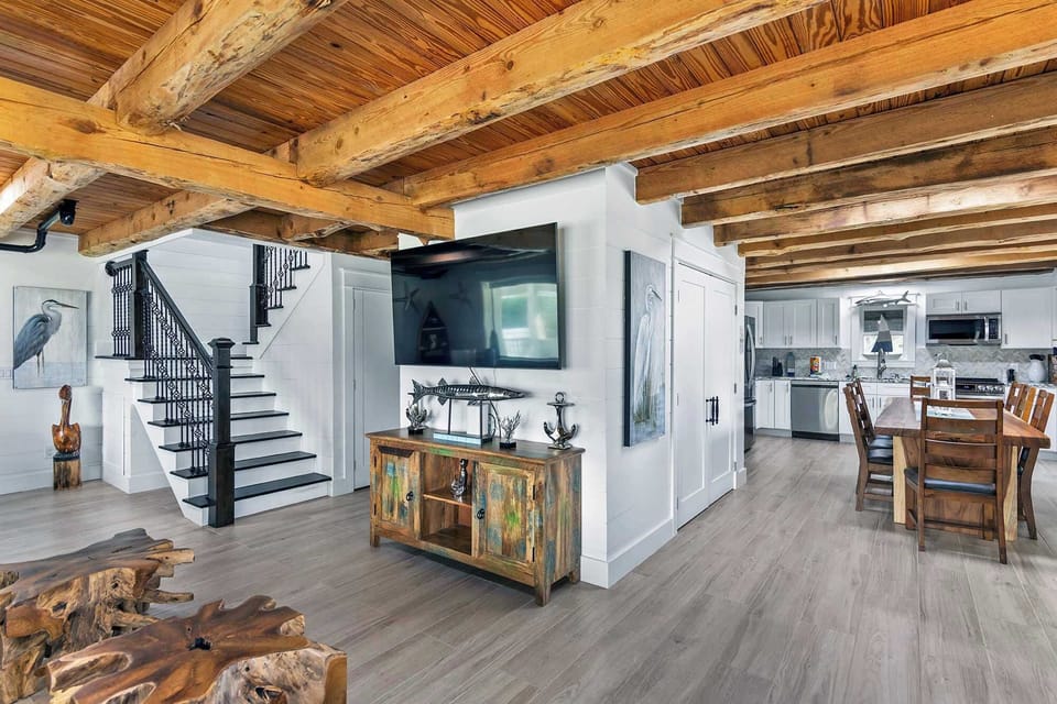 Open-concept living space w/ wood-beam ceilings & room to gather.