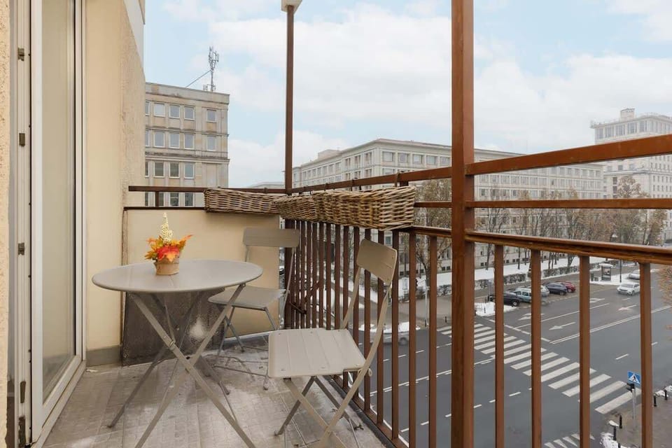 A charming balcony with a small table and chairs, perfect for enjoying coffee with a view.