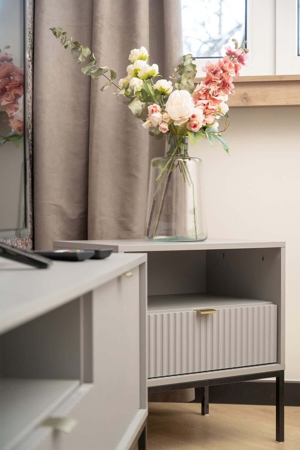 A close-up of a corner decorated with flowers and a radiator cover, adding warmth to the interior.
