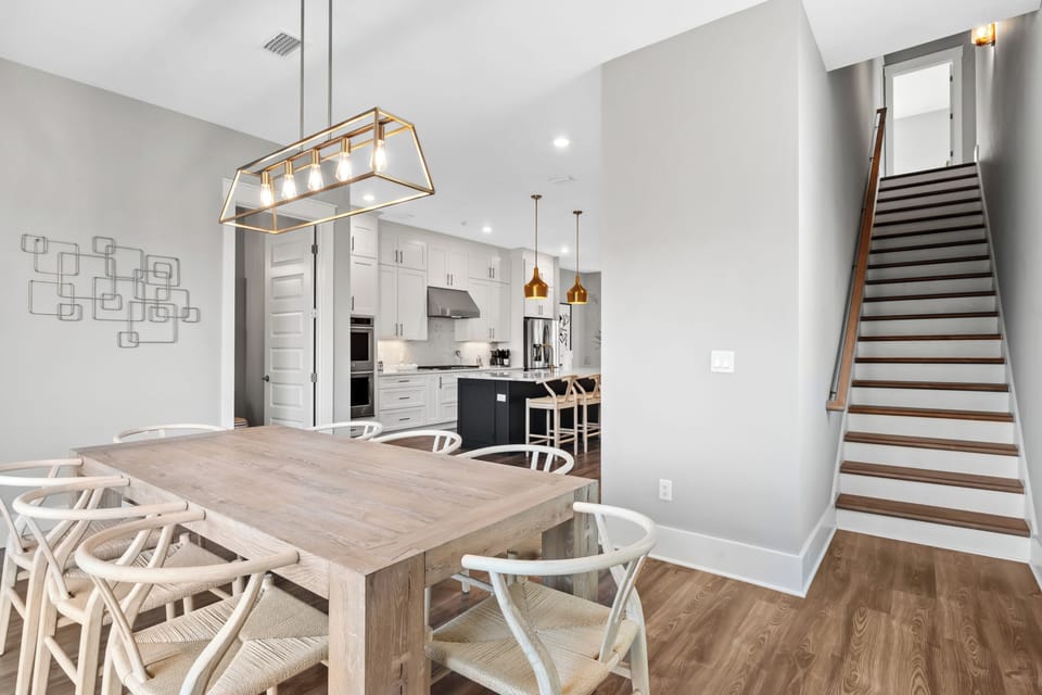 Airy dining space with designer lighting, seating for the whole group, and easy access to the balcony for indoor-outdoor meals.