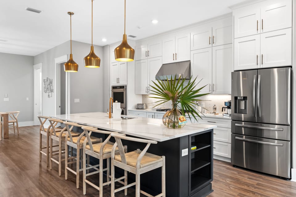 Designer kitchen with oversized island seating, stainless appliances, and statement lighting—perfect for gathering and entertaining.
