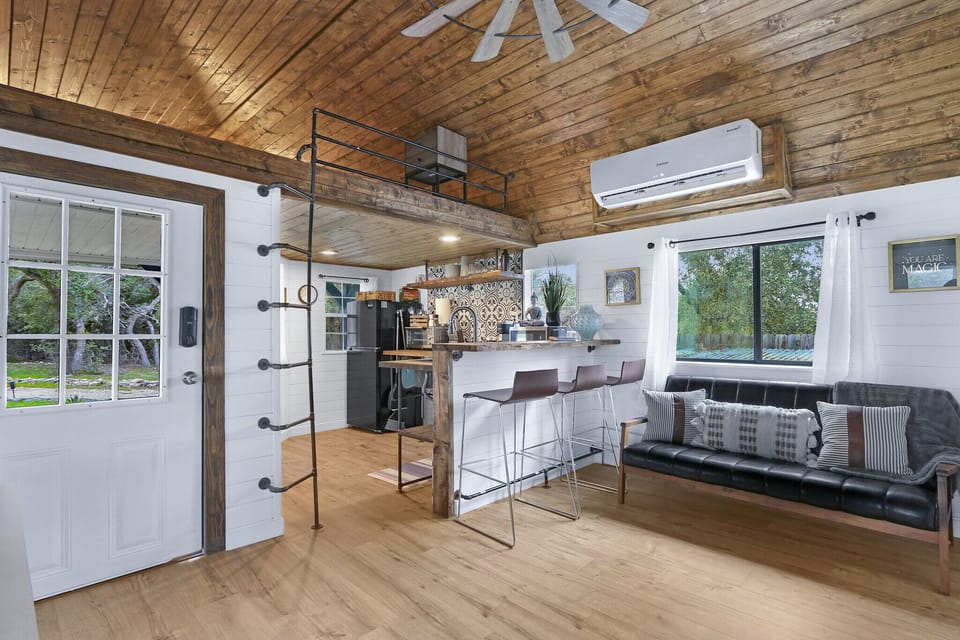 Just to the right of the entry door is the ladder leading up to the first loft which is over the kitchen.