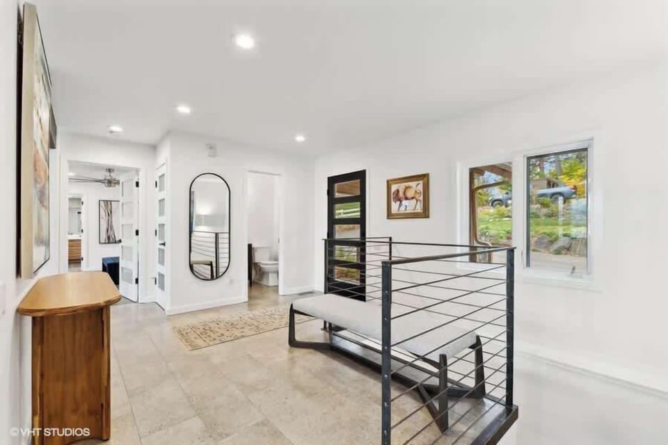 Main entrance and entry area showing powder room and railing leads to the downstairs