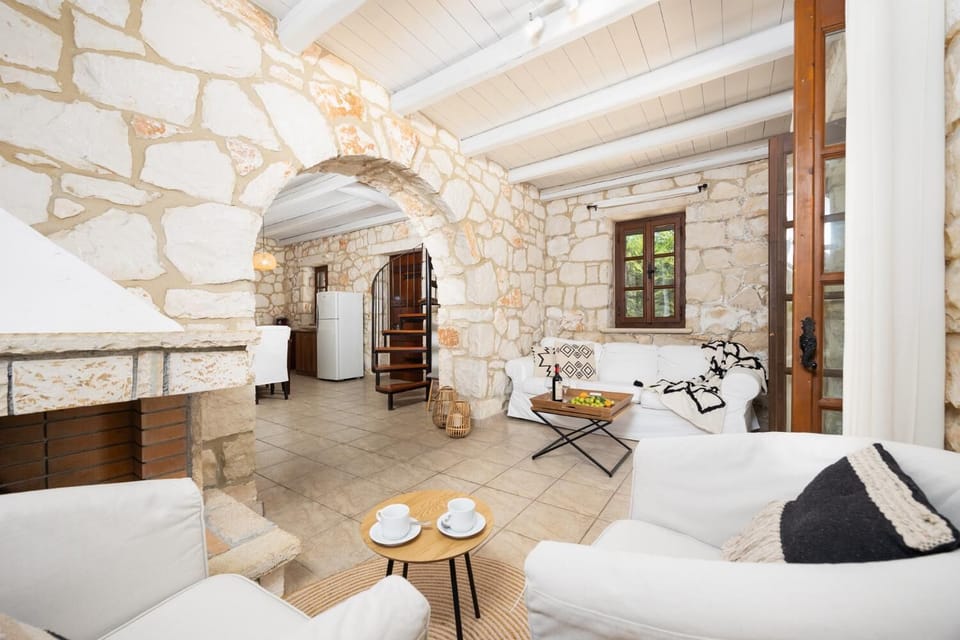 Open-plan living room with sofa, dining area, kitchen, ornamental fireplace, WiFi internet, and satellite TV