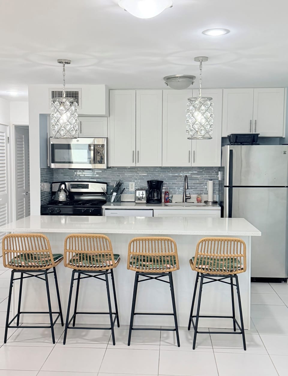 Fully renovated kitchen with quartz countertops and tile backsplash