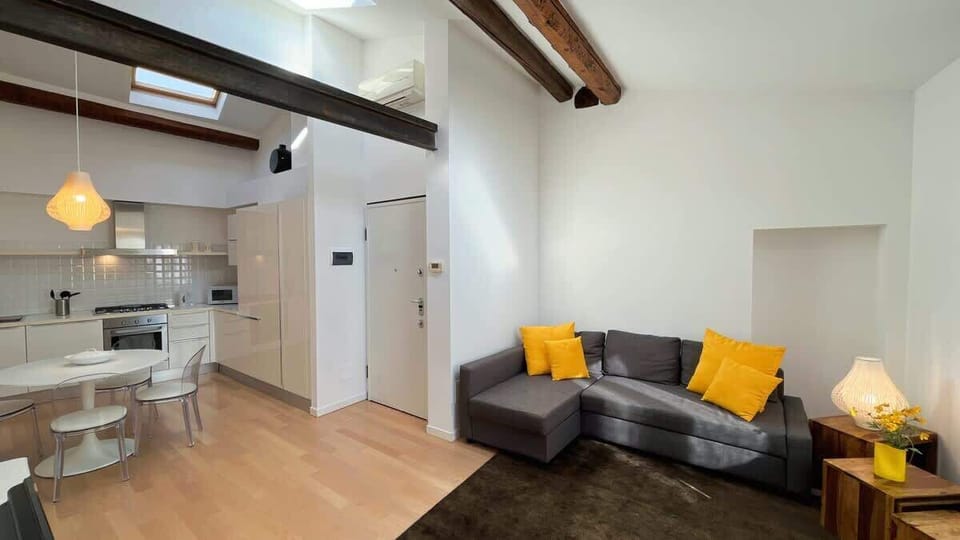 very spacious and welcoming living room, with comfortable sofa and white walls which contribute to make more bright the apartment