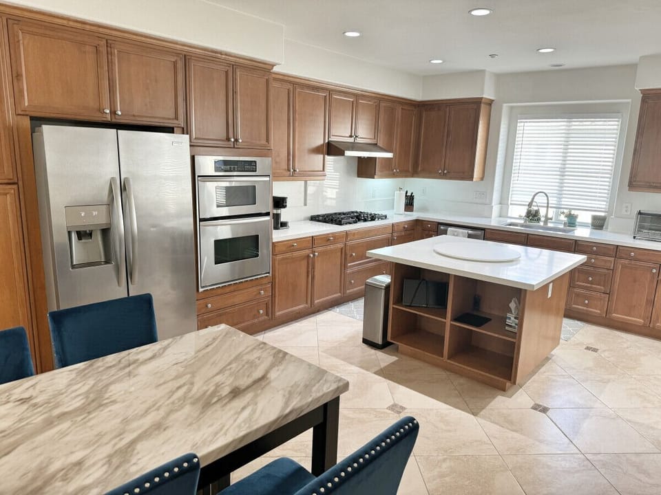 Large kitchen with stainless steel appliances and island.