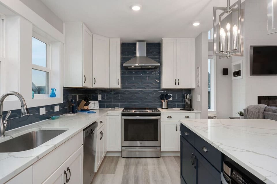Sleek kitchen details w/ crisp cabinetry, dark countertops & a polished finish.