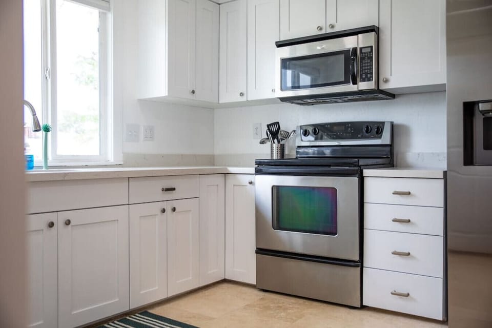 Well-equipped kitchen with stove, oven, and utensils.