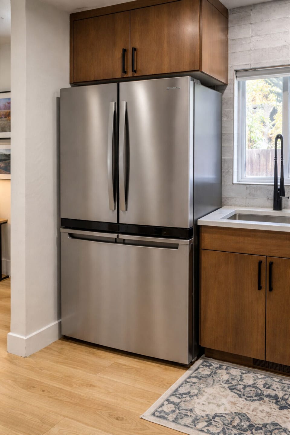 Kitchen featuring a stainless steel refrigerator and nearby sink for everyday use.