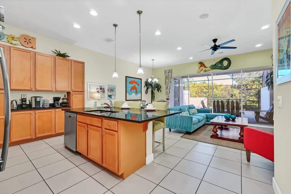 Open kitchen and living area with a large island and sliding doors to a screened patio.