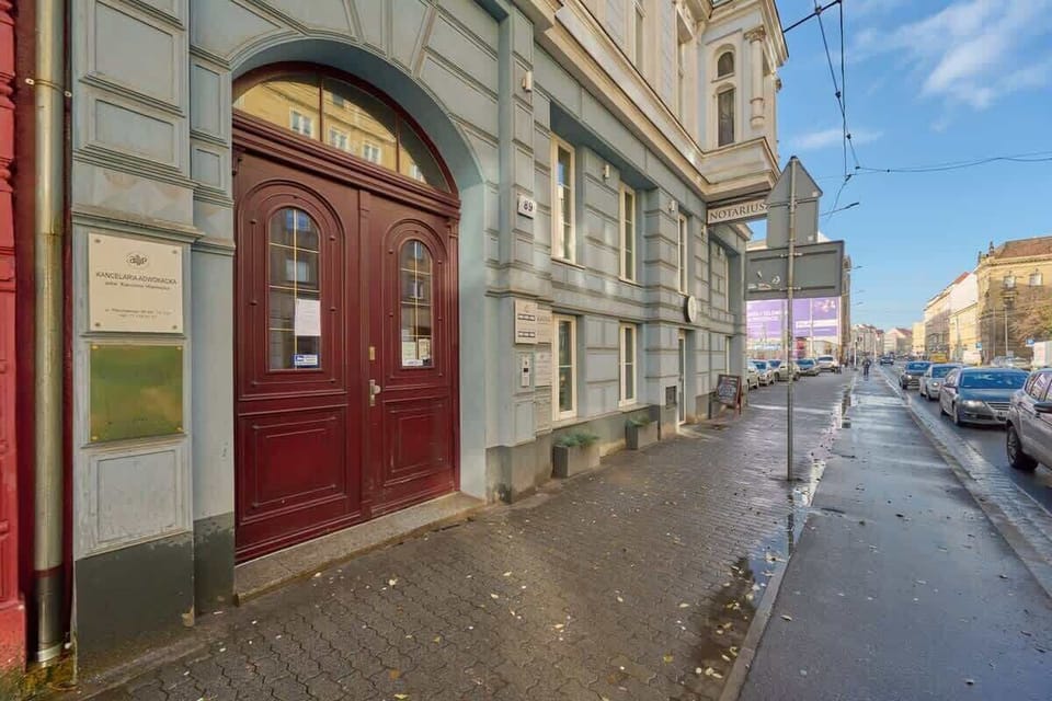 The entrance to the building with a traditional archway and a glimpse of the bustling street, adding a touch of old-world charm.






