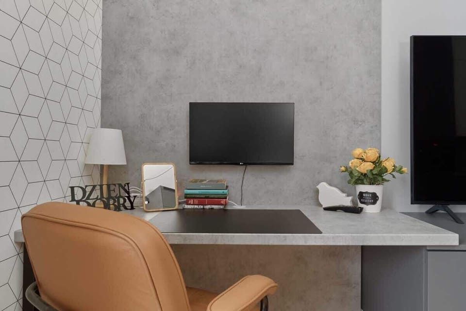 A well-organized workspace with a computer monitor, desk decor, and a leather office chair, ideal for remote work or study.
