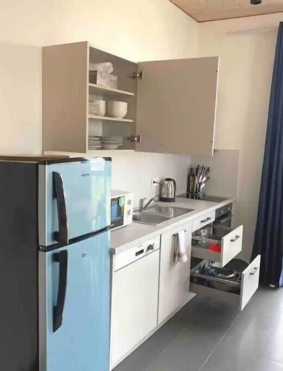 A fully equipped kitchen with stove, oven, kettle, dishwasher and freezer