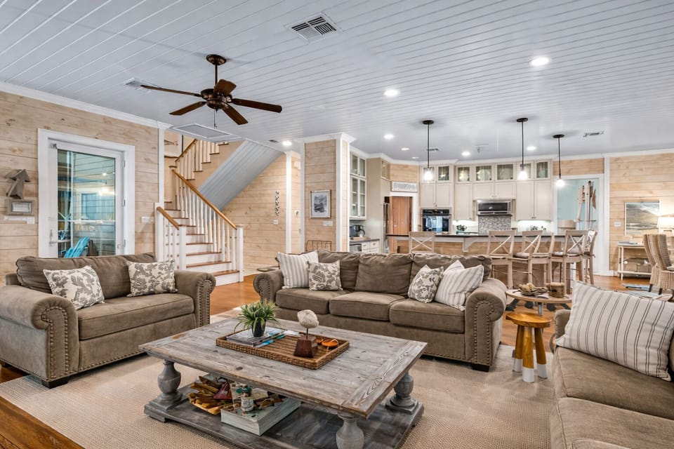 Large coastal living room with plush seating, wood accents, and open layout—perfect for group stays in Galveston.
