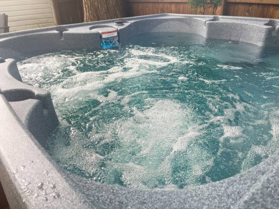 Indulge in relaxation in the shared hot tub outside, offering a serene oasis after a day of exploring. Perfect for unwinding under the stars.