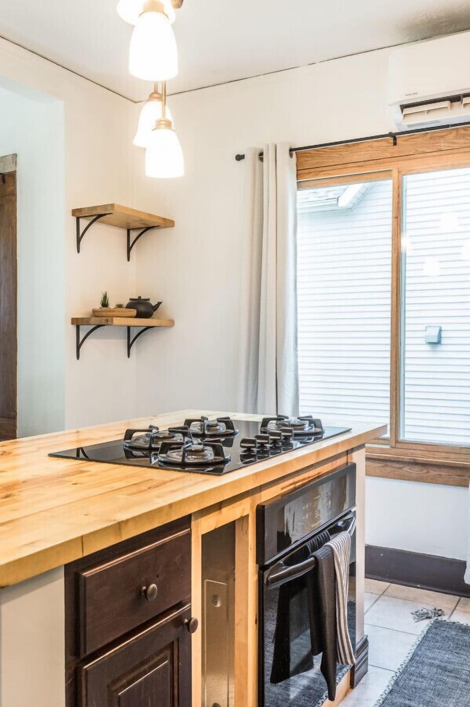 Step into our stylish kitchen adorned with charming wood-accented lighting fixtures and elegant heavy curtains draping over the windows. Revel in the perfect blend of modern functionality and rustic charm.