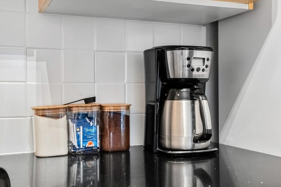 Full kitchen with a blender, crockpot/slow cooker, drip coffee machine, ground coffee, tea, sugar, and basic condiments (ketchup, mustard, relish.)