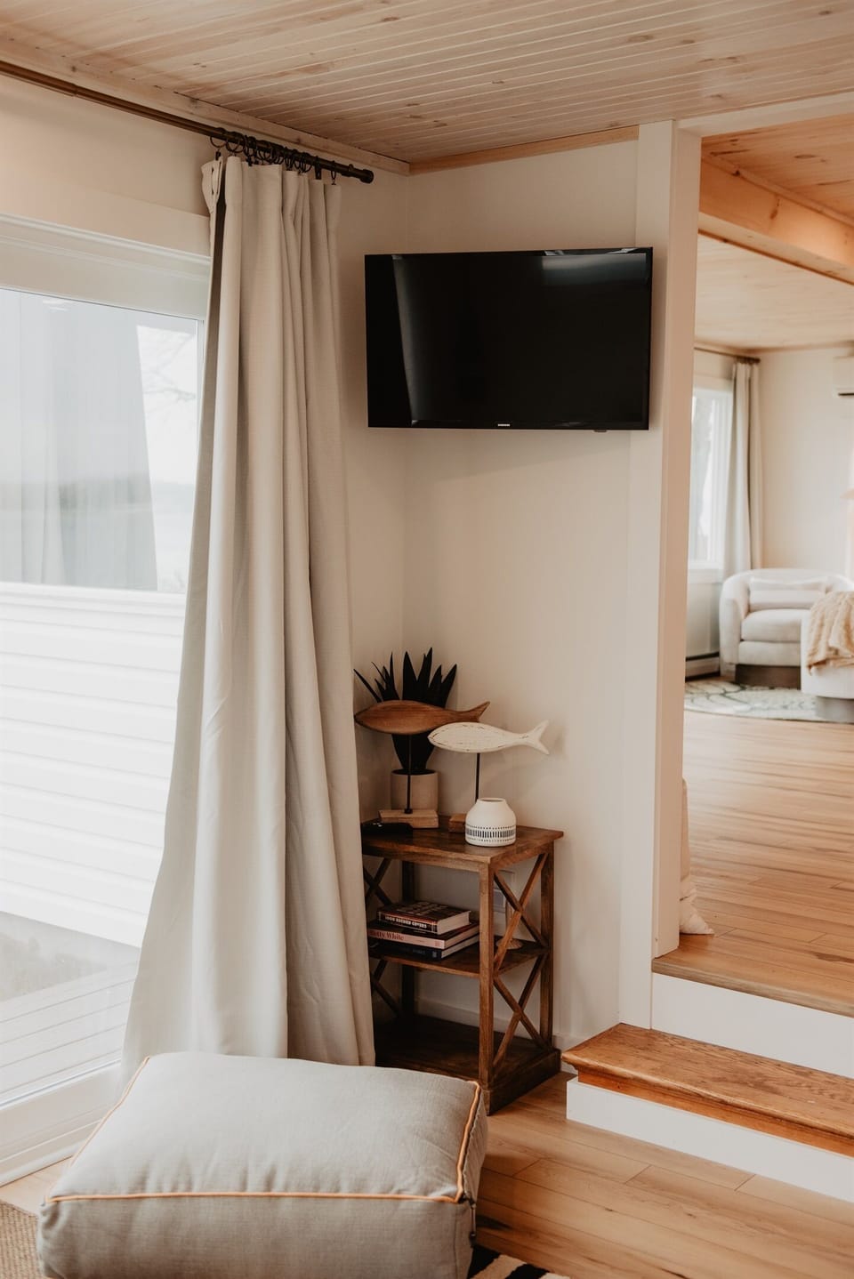 Spacious sunken living room with Smart TV, extra-large sliding doors to the lake, and stairs leading to the second floor—perfect for gathering the whole family.