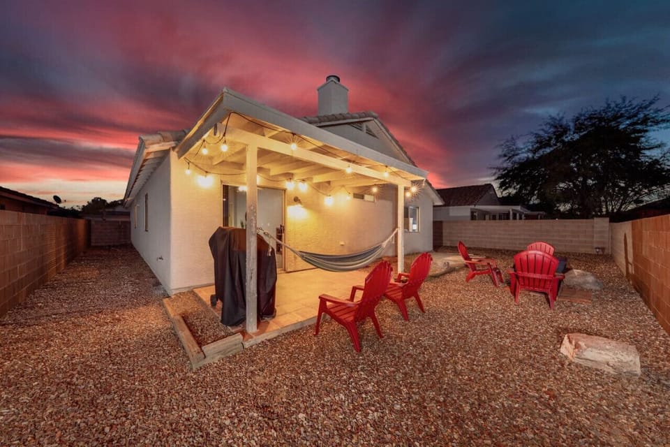 Fully fenced backyard with covered back patio, new propane grill, hammock, Adirondack chairs, and propane fire pit