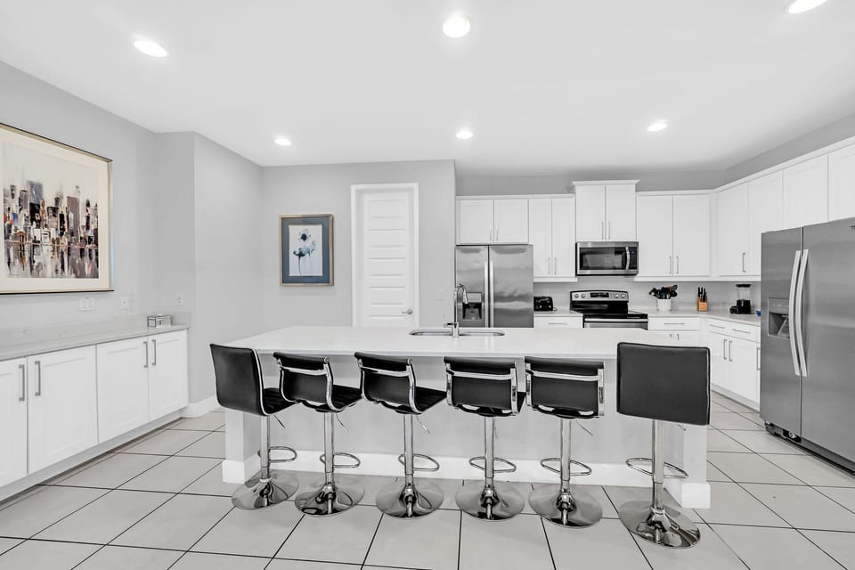 Sleek, modern kitchen with spacious island and bar seating, perfect for social cooking and casual meals.
