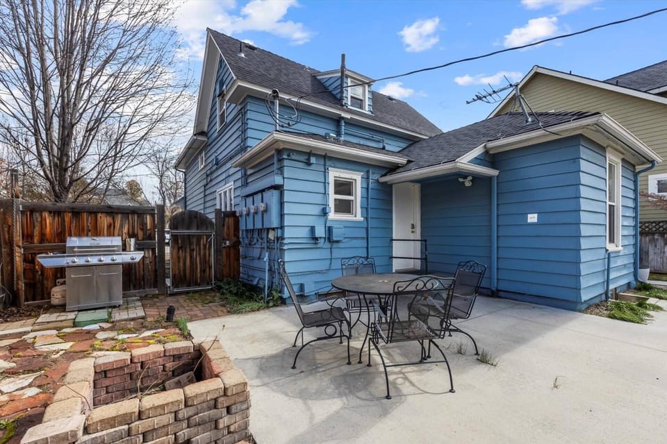 Back patio with fire pit, outdoor dining table, and BBQ