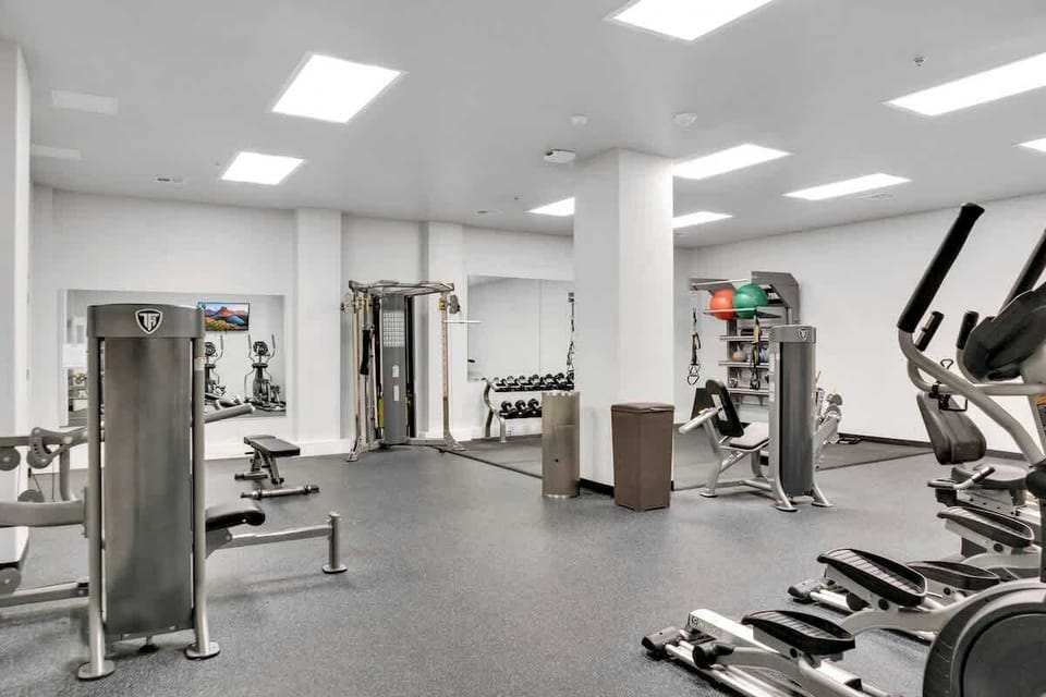 Well-equipped workout space with cardio equipment, resistance machines, free weights, and open exercise areas.