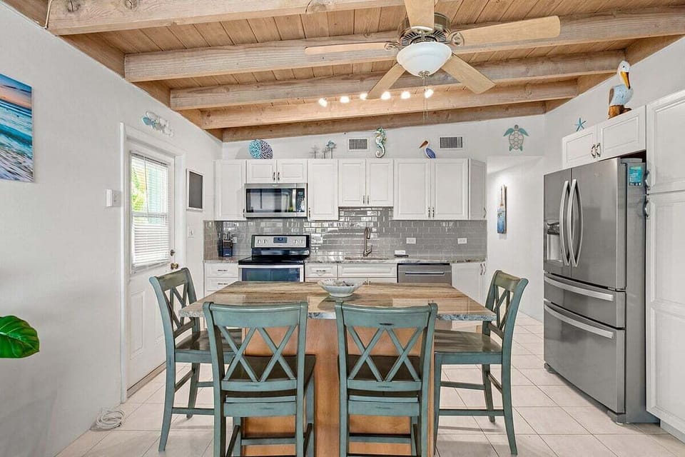 Prepare meals in a bright kitchen featuring full-size appliances, generous cabinetry, and a convenient breakfast bar.