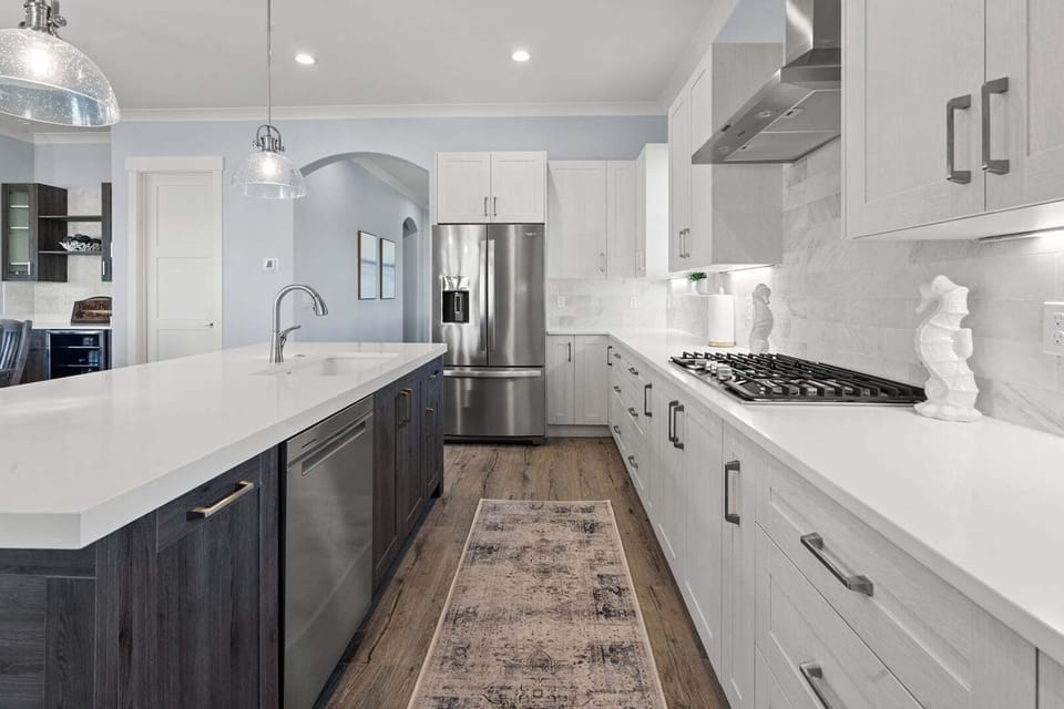 Cooktop, wall ovens and white cabinetry in the kitchen at Vistas Del Sol in North Myrtle Beach