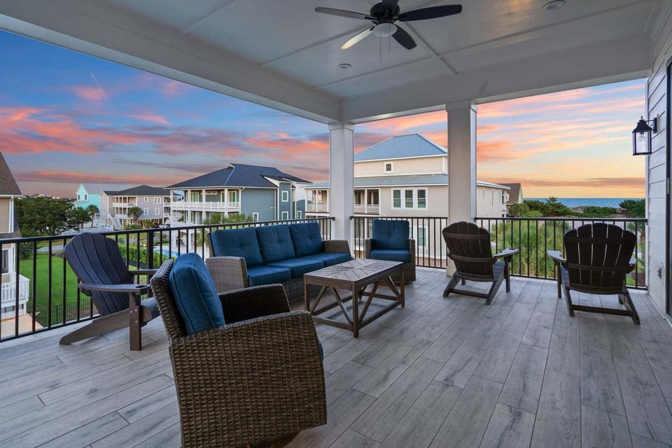 Covered porch with ocean view and cushioned seating at Vistas Del Sol, a 5-bedroom Tilghman Beach vacation rental