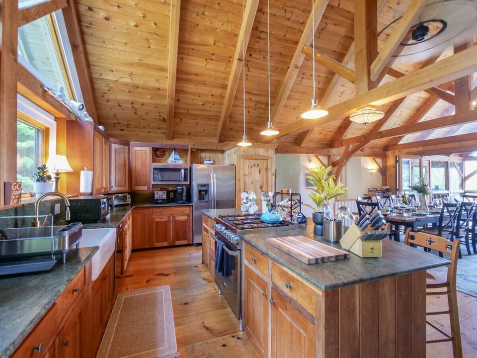 The open kitchen includes every convenience, a Miele dishwater, Bertazonni gas oven and stove, pod & drip Keurig coffee machine and disposal in an oversized stone sink