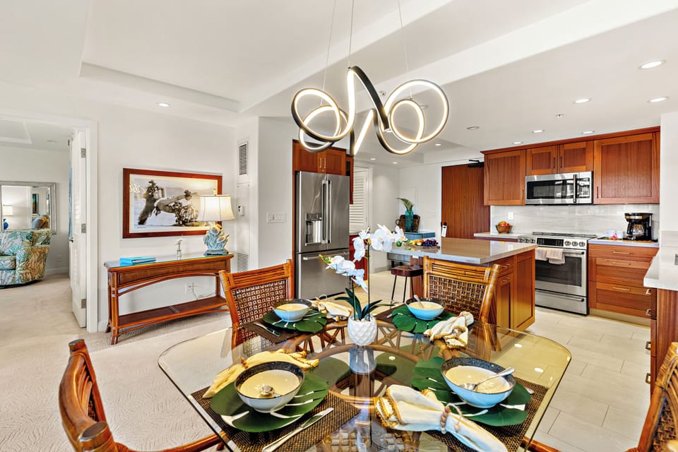 Bright and inviting open-concept kitchen featuring warm wood cabinetry, sleek granite countertops, and a spacious island that flows seamlessly into the living and dining areas. Perfect for entertaining or relaxing in comfort.