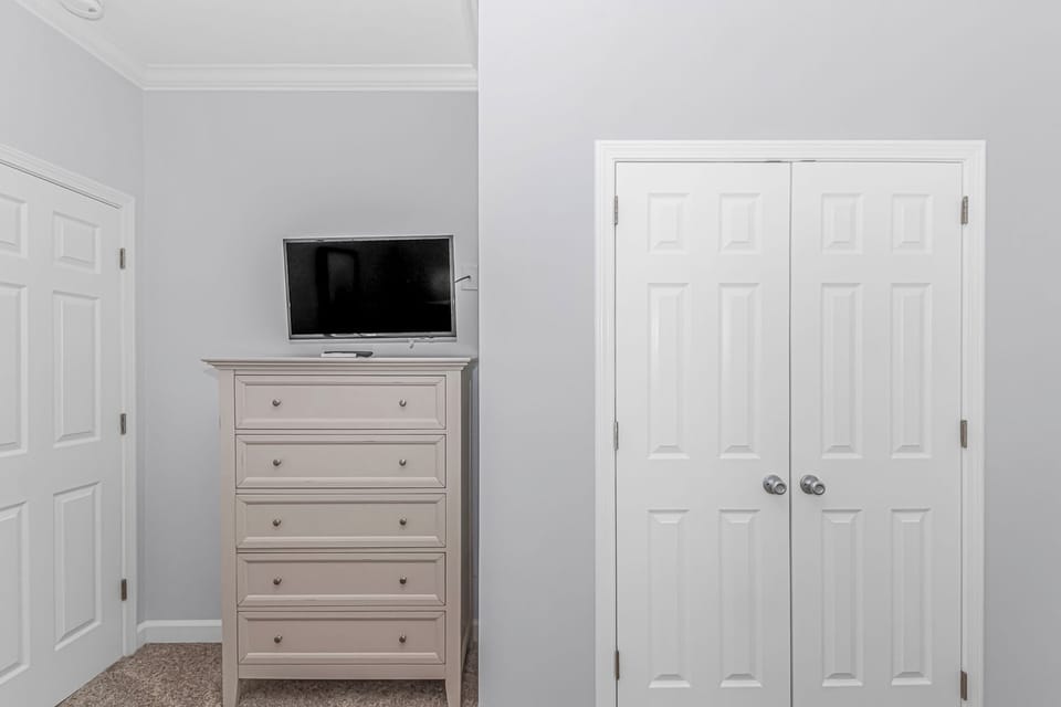 Television and closet for guest room with two full beds