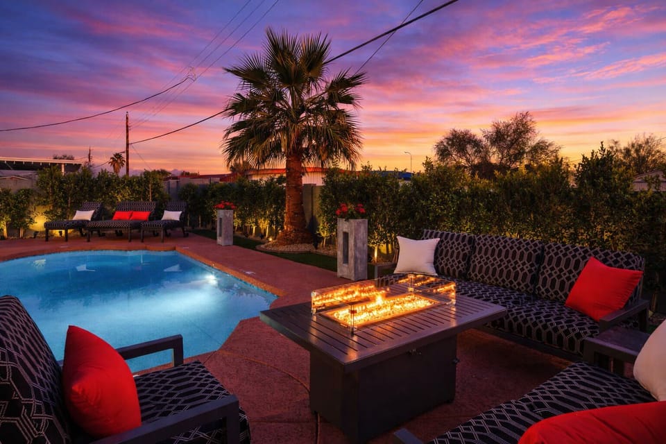 Outdoor patio with heated optional pool, hot tub, fire pit, outdoor dining area, BBQ, and cornhole.