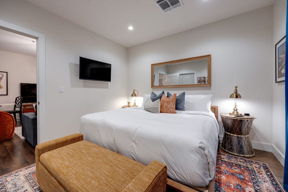 Drift off into a tranquil slumber in this well-appointed bedroom featuring a sumptuous bed, thoughtfully designed to enhance your viewing pleasure with a modern TV.