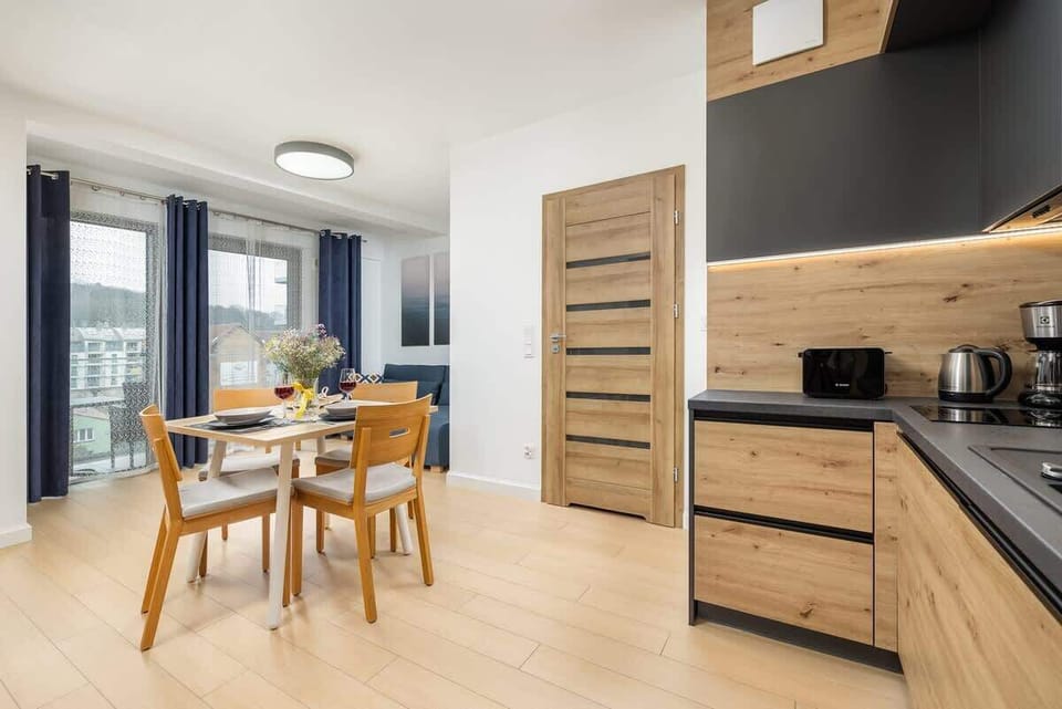 A well-lit dining area with modern wooden furniture and a view of the cityscape, enhancing the dining experience.

