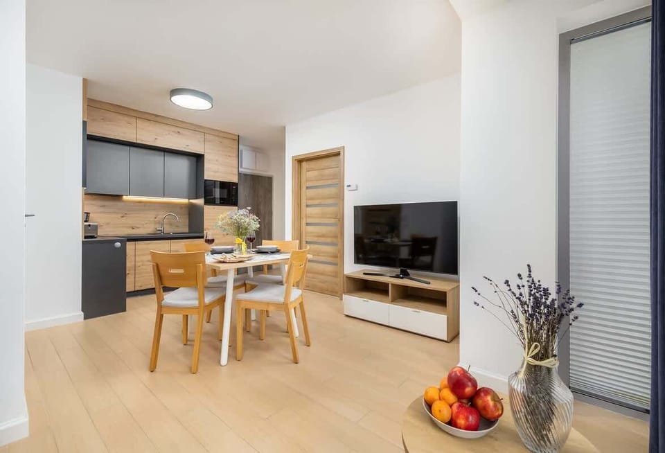 An open-plan kitchen and dining area with wooden accents and a cozy decor, ensuring a warm and welcoming atmosphere.

