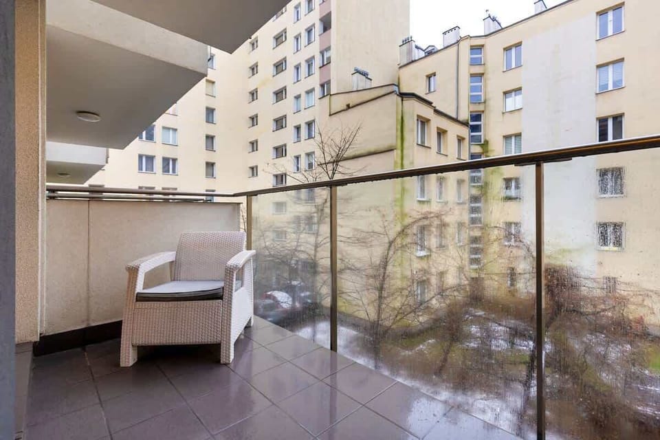 Another balcony view showing cozy outdoor seating with a scenic urban backdrop, perfect for leisure time.

