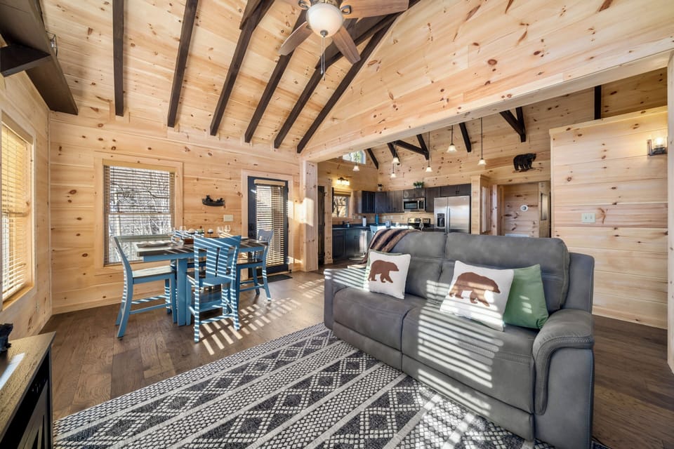 Bright rustic cabin with vaulted ceilings, cozy seating, and open living space