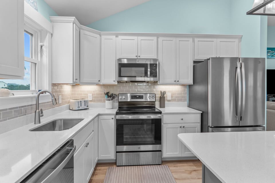 The kitchen's stainless steel appliances and airy features are sure to delight even the pickiest cooks.