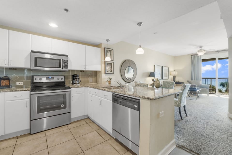 Modern kitchen with stainless steel appliances and an open view to the living area.