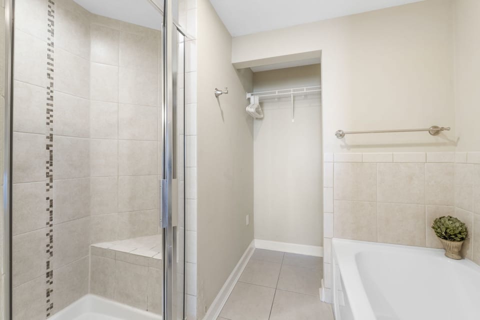 Modern bathroom featuring a glass-enclosed shower and a spacious bathtub.