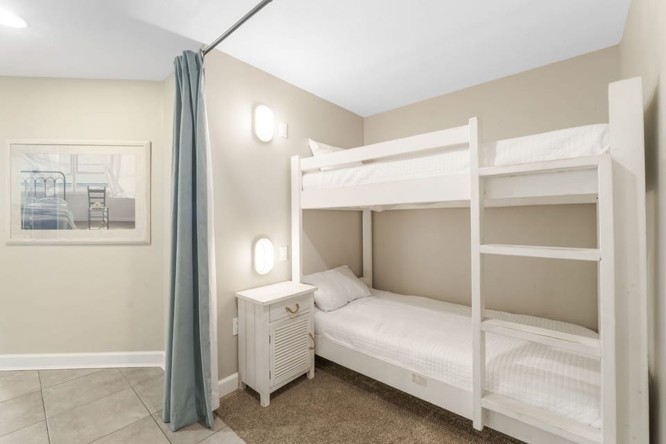 Compact bedroom featuring a white bunk bed and soft lighting for a cozy stay.