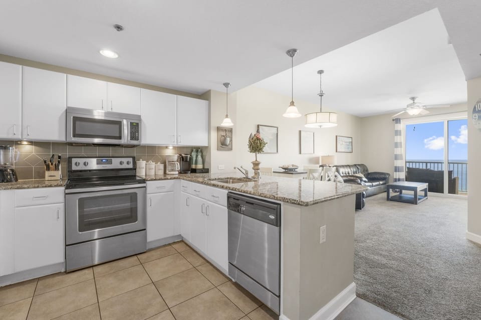 modern kitchen with stainless steel appliances and an open view to the living area