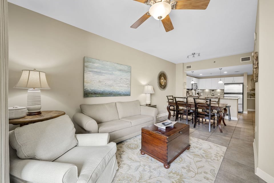 Open living and dining area with comfortable seating and a modern kitchen in the background