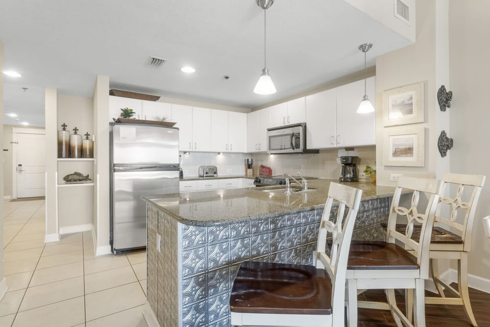 Modern kitchen with stainless steel appliances and a breakfast bar for casual dining.